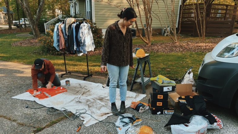 Outdoor setup with Caterpillar gear, including safety vests, hard hats, and various workwear items being prepared and organized.