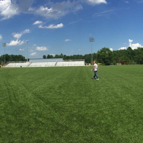 Expansive soccer field under a clear blue sky, showcasing an ideal setting for athletic training and practice.
