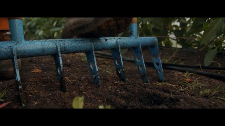 Close-up of a farming tool preparing the soil at Sankofa Farms, emphasizing sustainable agricultural practices.